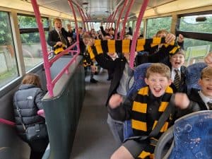 Children enjoying a fun bus ride at Inchmarlo with smiles and laughter.