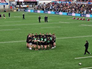 Young rugby team huddled on field before match at Inchmarlo.