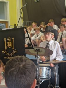 Students performing music at Inchmarlo school event, showcasing academic and extracurricular excellence.