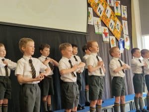 Students performing on stage at Inchmarlo, showcasing excellence in education and community involvement.