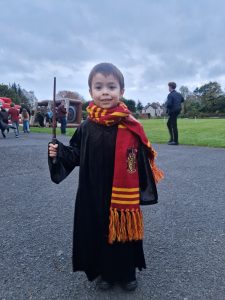 Young boy in graduation gown and scarf outside at Inchmarlo estate.