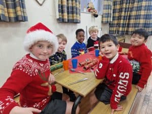 Children celebrating Christmas at Inchmarlo school with holiday sweaters and decorations.