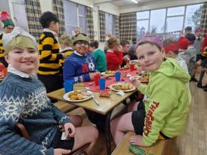 Children enjoying festive holiday meal at Inchmarlo, Christmas celebrations, cheerful atmosphere.