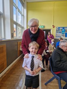 Happy woman with young student in classroom setting.
