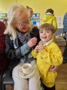Smiling elderly woman with a young boy enjoying a social event at Inchmarlo.