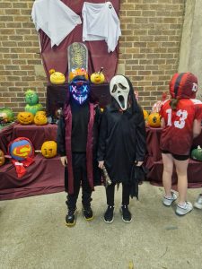 Children in masks at Halloween event in Inchmarlo Gardens, festive outdoor celebration.