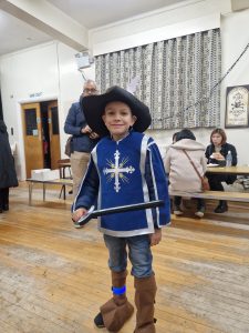Boy dressed as a medieval knight with sword at Inchmarlo event.