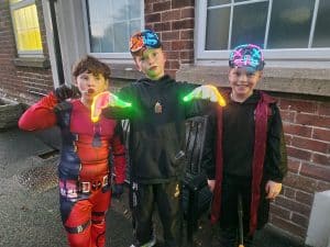 Three kids in costumes enjoying outdoor activities at Inchmarlo outdoor space.