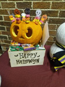 Festive Halloween pumpkin with ghosts and candies for celebration at Inchmarlo. Perfect for seasonal decoration.