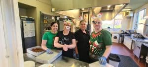Friendly staff preparing food in Inchmarlo community kitchen.
