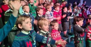 Children singing Christmas carols at Inchmarlo with festive cheer and community spirit.