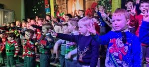 Children in festive Christmas outfits performing at Inchmarlo school event.