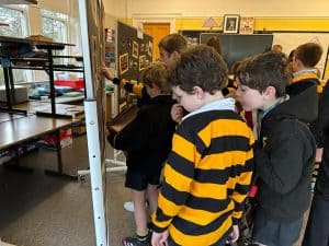 Students exploring exhibits at Inchmarlo School, engaging in educational activities indoors.