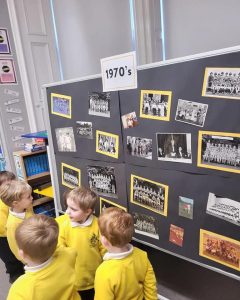 Children viewing historical photos at Inchmarlo school exhibit.