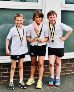 Three children with medals after sports day at Inchmarlo School.