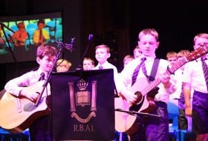 Students performing with guitars at Inchmarlo event.