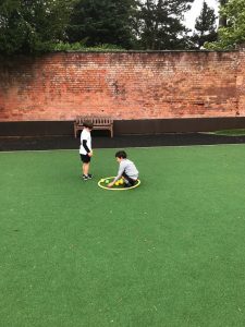 Two children playing on a green artificial turf at Inchmarlo estate.