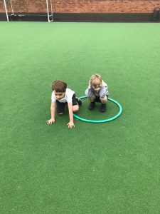 Two children playing on a vibrant green playground surface at Inchmarlo.
