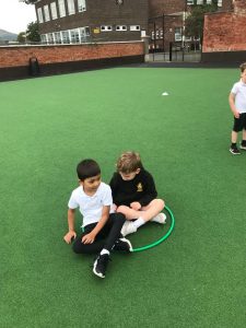 Children playing on green artificial turf at Inchmarlo outdoor area.