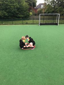 Group of children playing on the green outdoor sports field with goalpost at Inchmarlo.