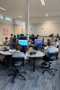 Students working on computers in a modern classroom setting.