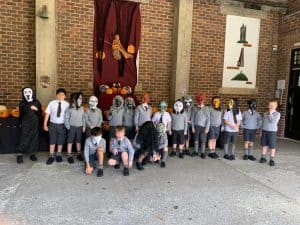 Group of children in school uniforms with masks outdoors at Inchmarlo.