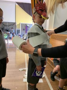 Child wearing a feathers mask at Inchmarlo school event, engaging in a creative activity.