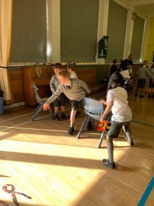 Children playing in a bright, spacious indoor activity room at Inchmarlo care home.