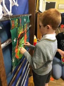 A young boy creating a colorful birthday greeting card with festive decorations.