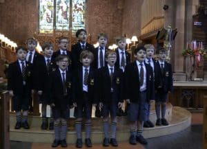 Group of young students singing in a historic church interior.