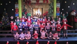 Children's choir performing holiday songs on stage at Inchmarlo.