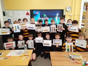Children in classroom holding colorful educational posters at Inchmarlo School.