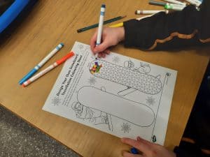 Child drawing coloring worksheet at Inchmarlo nursing home.