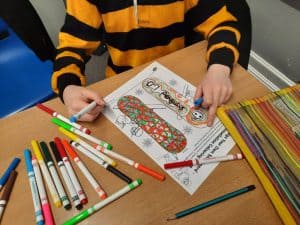 Child coloring at Inchmarlo care home, engaging in creative activities for well-being and entertainment.