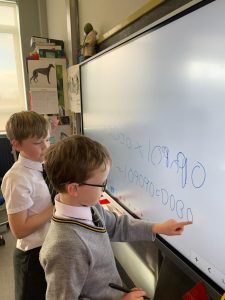 Children engaging with interactive whiteboard learning activity.