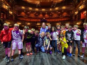 Children enjoying a performance at Inchmarlo Theatre in a grand, historic venue.