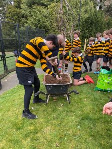 Children planting trees at Inchmarlo, a scenic estate with lush gardens and outdoor activities.