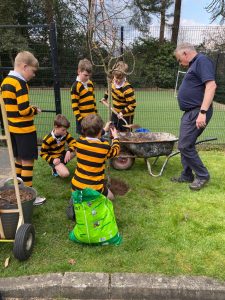 Children cooking outdoors at Inchmarlo estate sports day, enjoying nature.