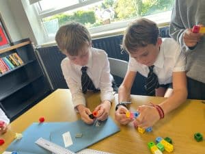 Children playing with colorful building blocks in a classroom.