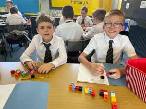 Young students playing with colorful educational blocks in classroom.