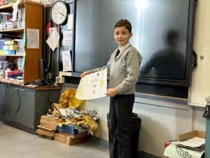 Young student presenting in classroom, engaging in educational activity, school environment, learning, and teaching.