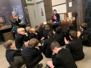 Students attentively listening to a teacher in classroom.