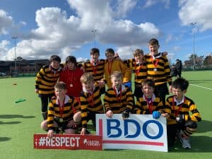 Young rugby players in striped jerseys at Inchmarlo sports field, practicing and playing rugby.