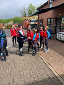 Children wearing backpacks lining up outside the Inchmarlo building for outdoor activity.