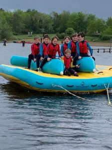 Group of children enjoying water activities on a blue inflatable raft at Inchmarlo.