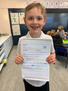 Happy student holding a schoolwork paper at Inchmarlo School.