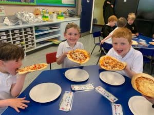 Children enjoying pizza at Inchmarlo preschool in Scotland.
