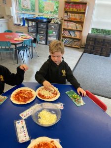 Children engaging in pizza making craft at Inchmarlo educational center.