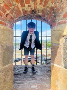 Young boy in school uniform enjoying a view at Inchmarlo estate in Scotland.
