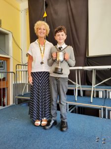 Bright young boy receiving award at Inchmarlo event, highlighting educational achievements and community engagement.